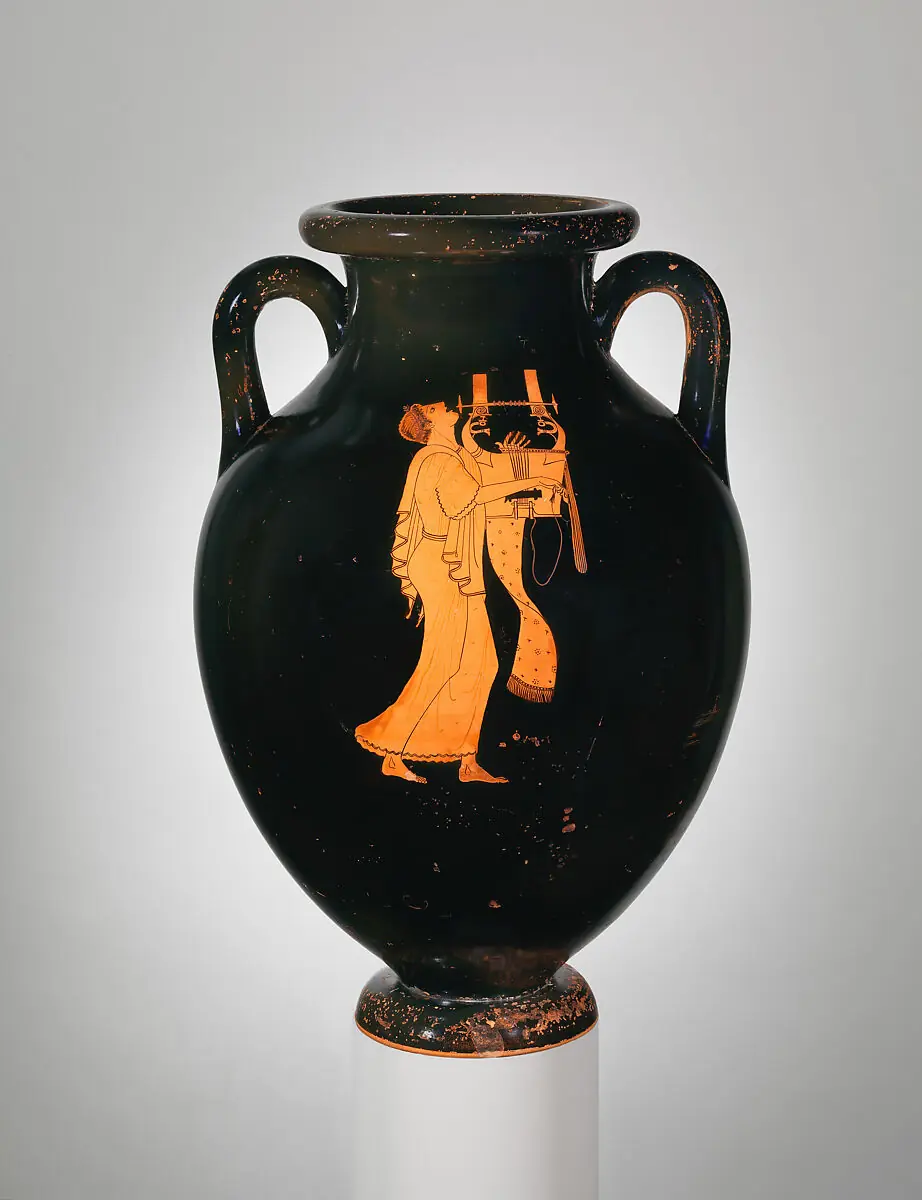 Black amphora with red figures: a young man in a long tunic, head thrown back, sings while playing the kithara.
